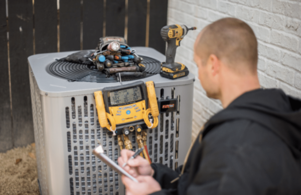 a professional technician installing a new outdoor air conditioner