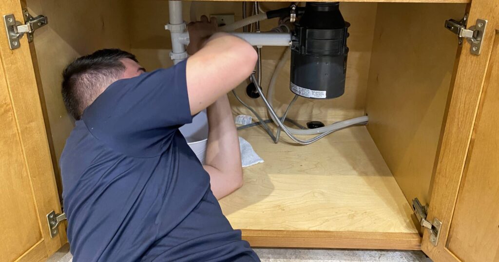 plumber fixing an issue with bathroom plumibing