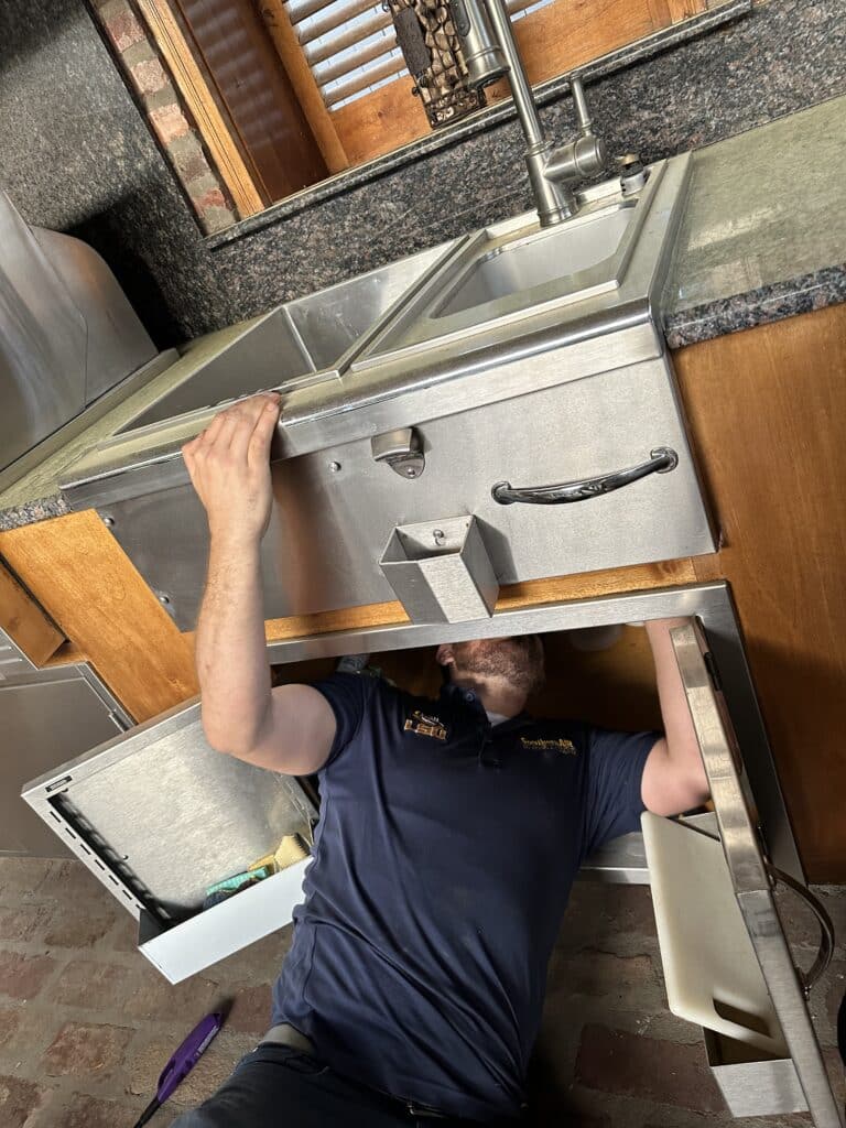 plumber performing a repair on kitchen sink