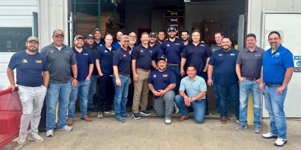 Team of HVAC and electrical technicians posing together in front of a service garage in Baton Rouge, Louisiana.