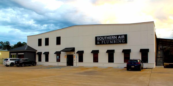 Modern white commercial building with black awnings and signage for Southern Air & Plumbing located in Louisiana.